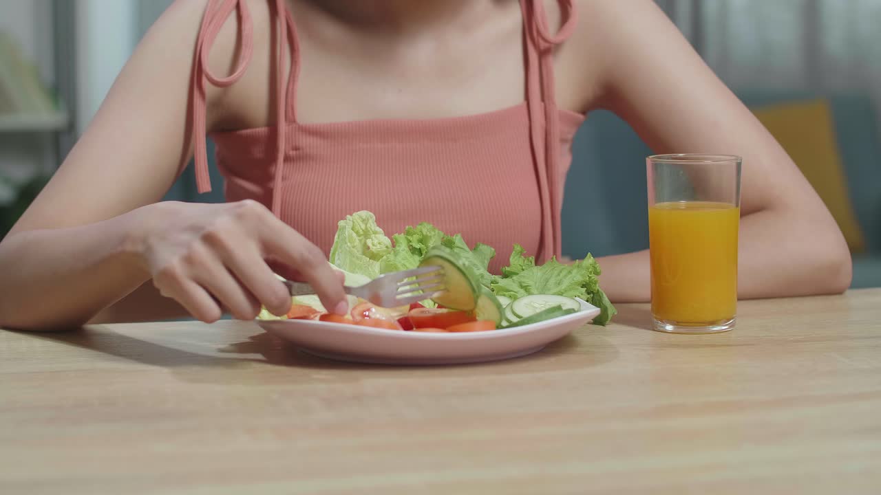 부에 앉아 있는 동안 포크를 고 호박을 는 건강한 음식과 오렌지 주스 한 잔을 가진 여성의 근접