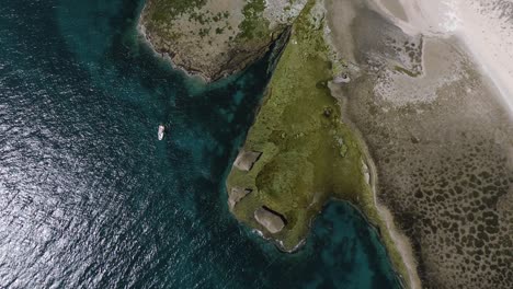 zodiac boat resting on tranquil sea of patagonia - aerial zoom-in shot