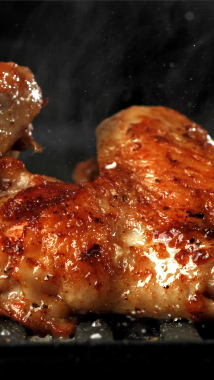 Pollo dorato che rosola e cuoce a vapore su una padella calda