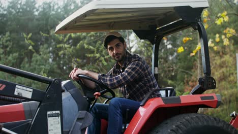 hombre conduciendo un tractor en un bosque