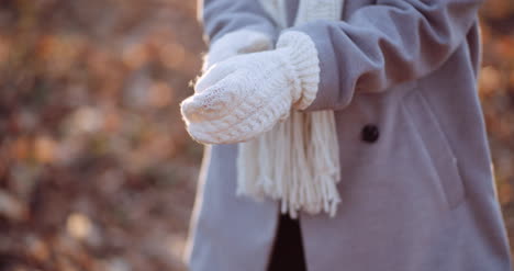 woman putting wool gloves on hands in winter