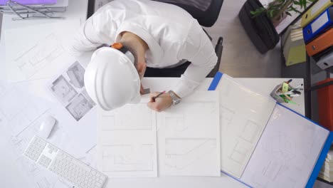 an architect drawing the perspective of the rooms of the house with a black pencil.