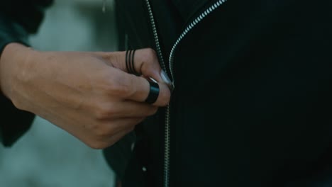 woman zipping a black leather jacket