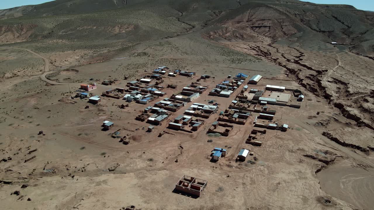 Drone aerial pullback over entire village site nestled in the desert terrain of Bolivia’s Sud Lipez region