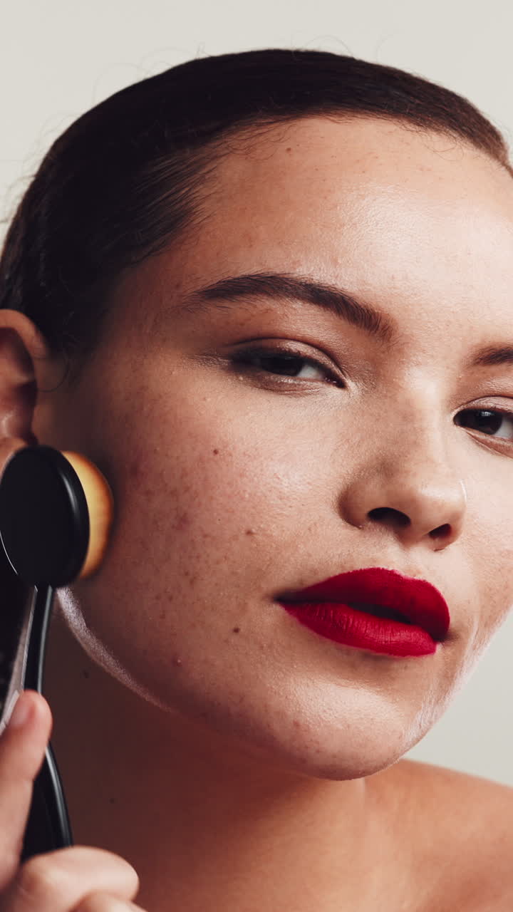 Young Woman Applying Makeup to Her Face with a Brush
