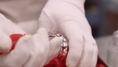 red gummy multivitamins manually bottled by gloved hands