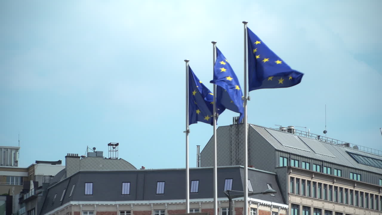 SLOW MOTION: European Union flags flying on a sunny day in Brussels