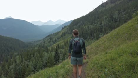 hikers walking downhill on a trail in high altitude rockies kananaskis alberta canada