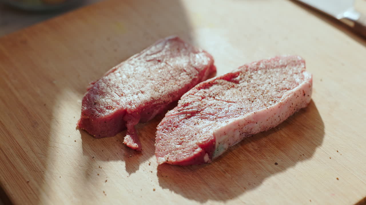 Two seasoned cuts of meat on a cutting board