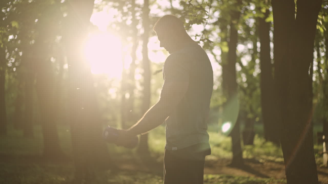 Man exercising with dumbbells in a park