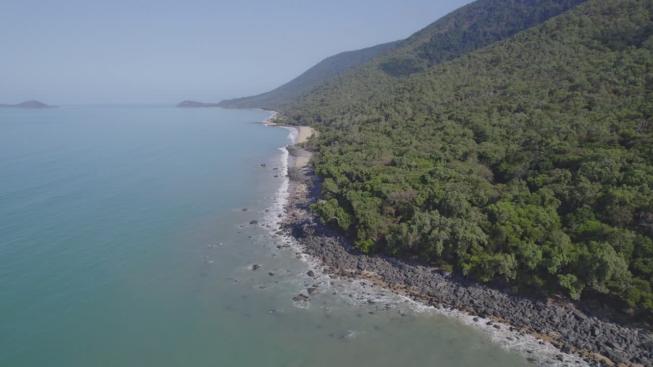 playa limítrofe con una exuberante vegetación en el tramo de costa entre cairns y port douglas en el extremo norte de queensland, australia