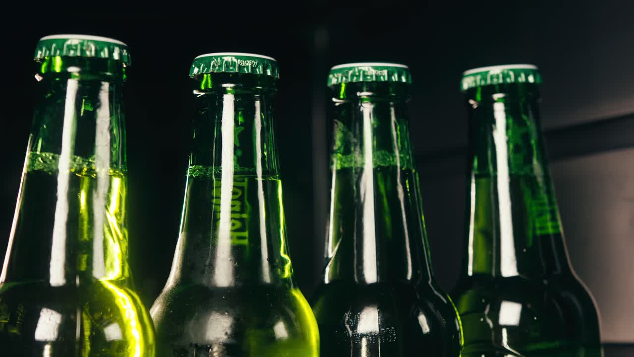 Row of beer bottles in fridge, shop or hotel, cold lager craft german beer or cider, shop supermarket or wine cooler close up.