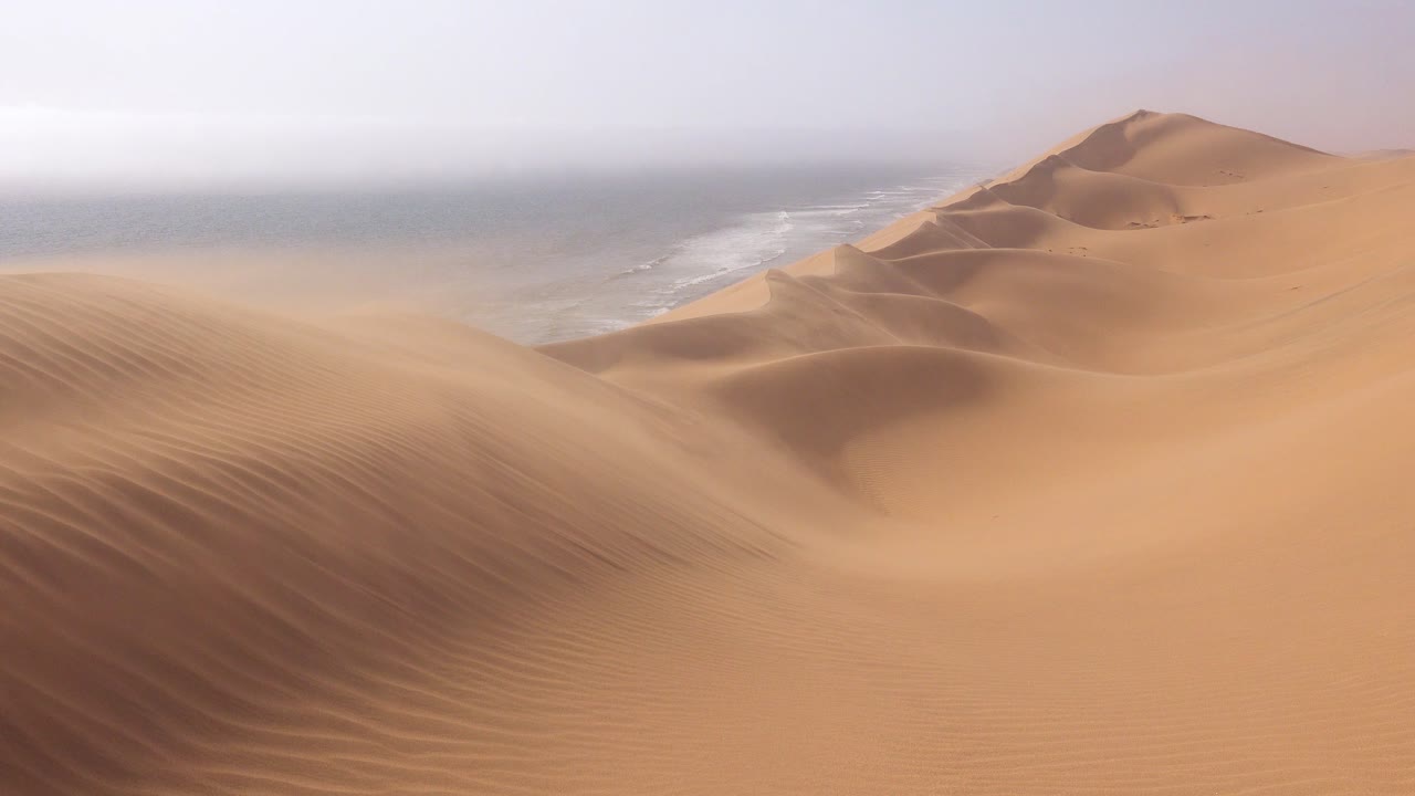 fuertes vientos soplan a través de las increíbles dunas de arena del desierto de namib a lo largo de la costa esquelética de namibia