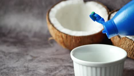 vertiendo aceite de coco en un recipiente en la mesa,