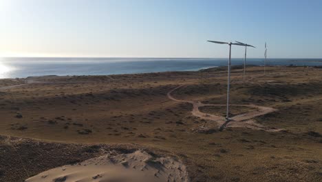 4K-Wind-turbines-front-to-sea-at-sunset-backlight-aerial-shot-renewable-energy-slow-motion-60FPS