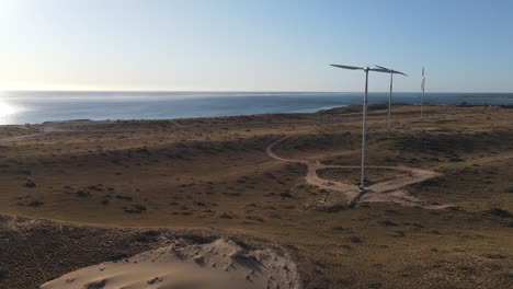 turbinas eólicas de 4k frente al mar al atardecer, toma aérea de luz de fondo, energía renovable, cámara lenta 60fps