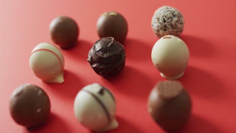 black and white chocolates on pink background at valentine's day