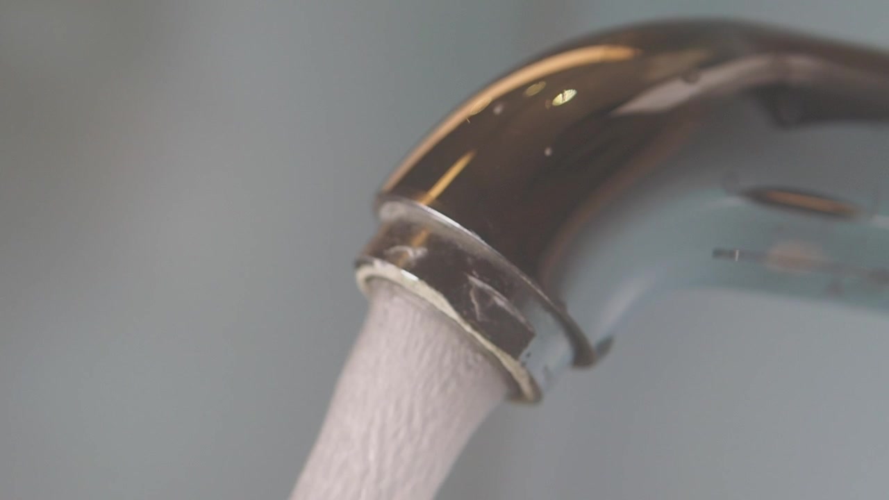 Acqua che scorre da un rubinetto da cucina cromato