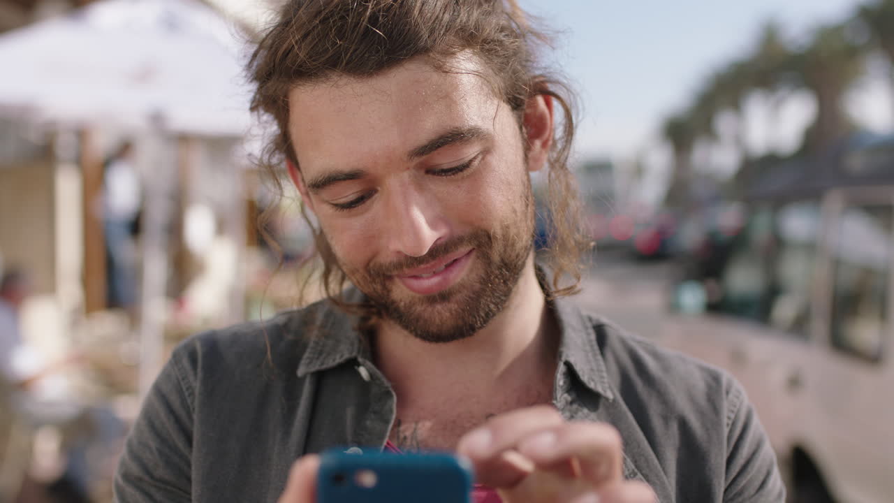 portrait of handsome young man smiling relaxed using phone