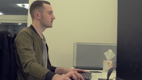 un empleado masculino trabajando en una computadora en la oficina