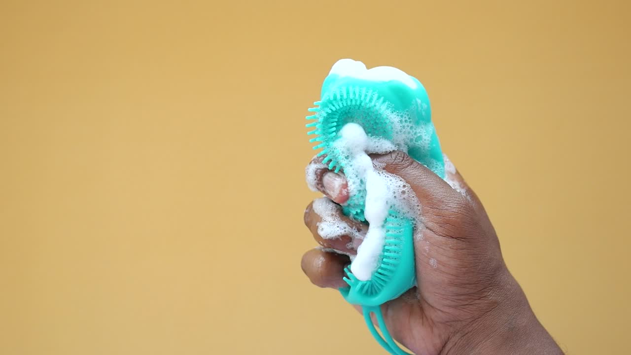 Teal Body Scrubber with Soap Foam in Hand
