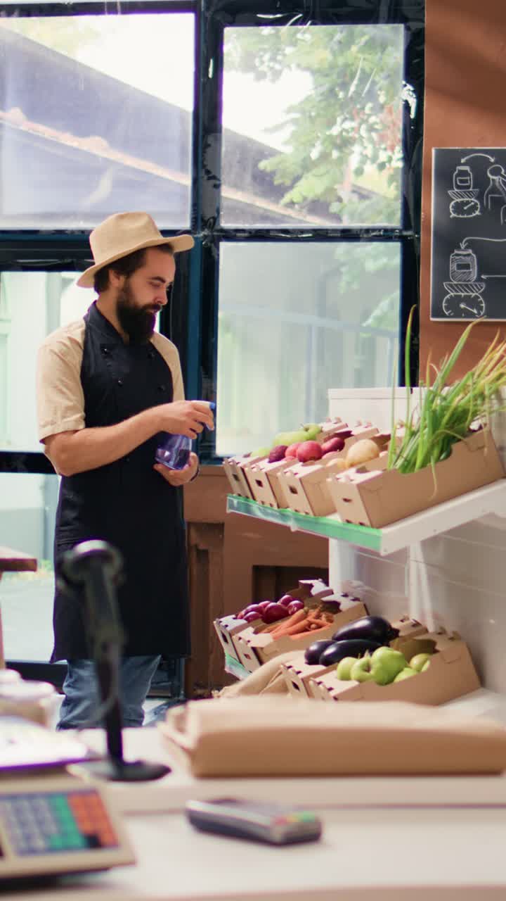 Vídeo vertical de comerciante borrifando produtos maduros