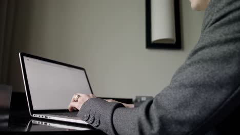 Side-view-of-mid-adult-caucasian-businesswoman-working-on-laptop-in-a-modern-hotel-4k