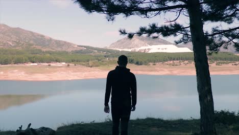 Silhouette-of-a-person-walking-arriving-at-a-lake