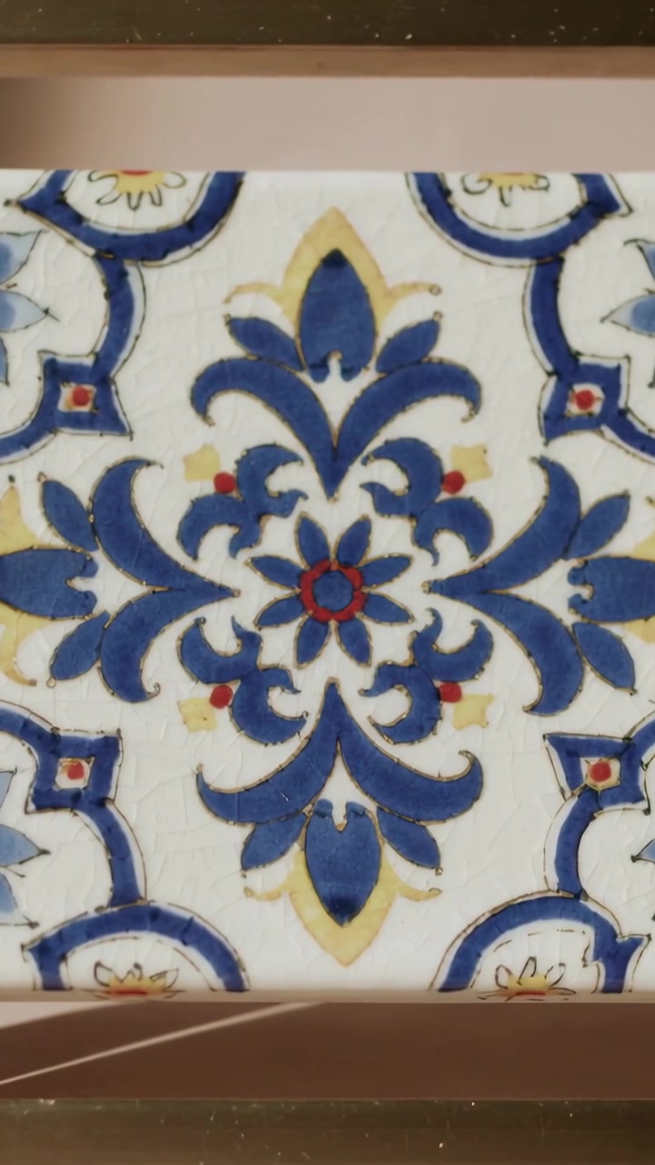 Video verticale: Telecamera che si inclina centrando una piastrella di ceramica sul muro per regolare l'inquadratura, medaglione blu.