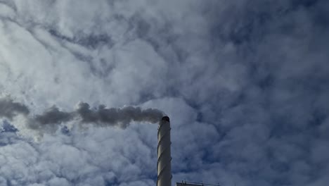 view of white smoke from chimney on blue sky background. ecology and greenhouse effect concept.