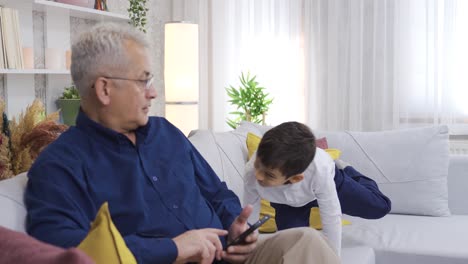 the father is looking at the phone and is not interested in his child.