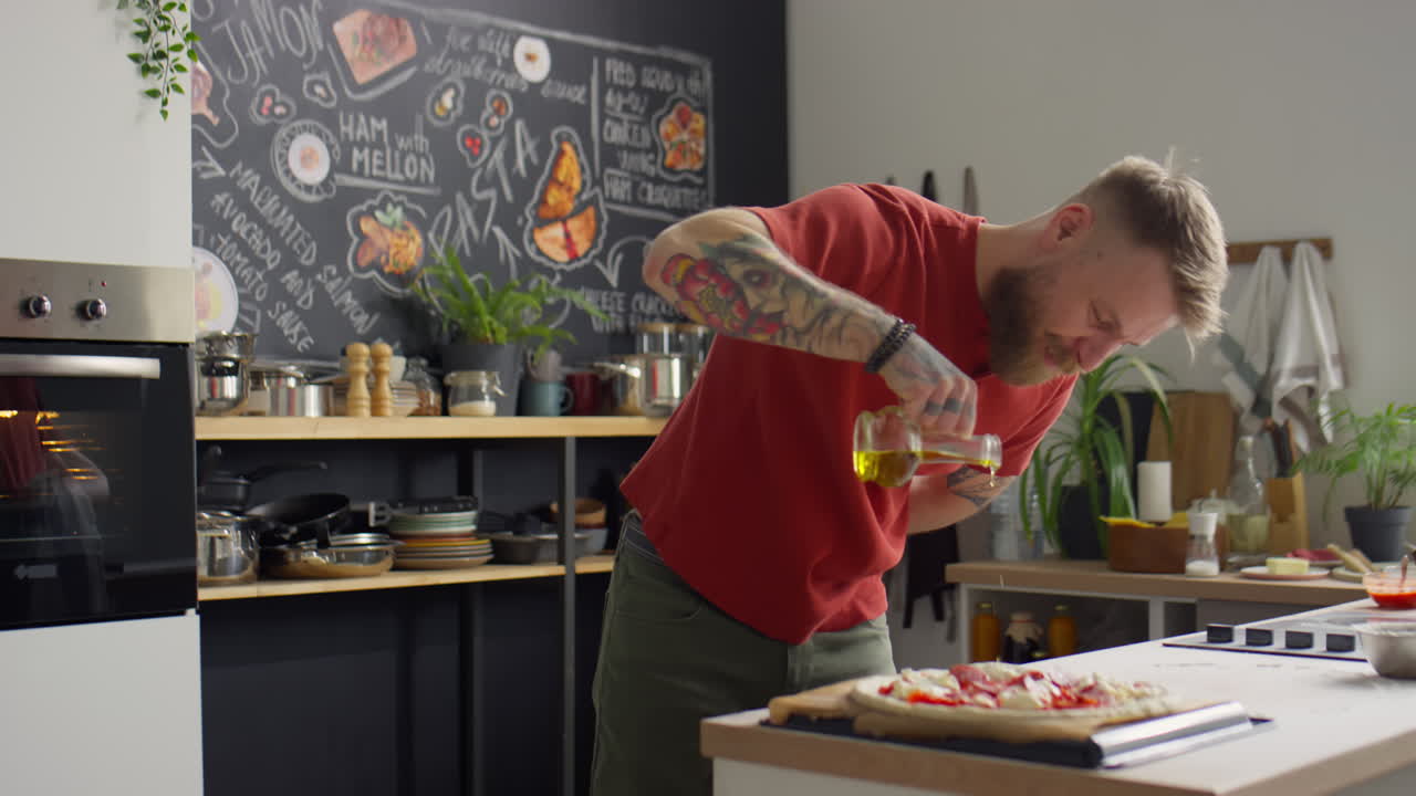 Chef Adding Olive Oil to Pizza