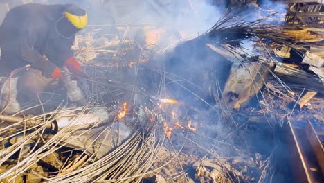 Close-up-of-worker-in-protective-equipment,-cutting-metal-scrap-with-gas-cutter