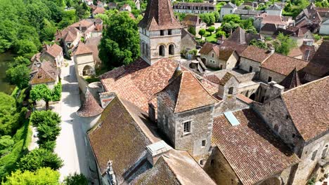 Small,-medieval-village-situated-next-to-a-river,-flowing-through-a-rich-forest-in-the-heart-of-France