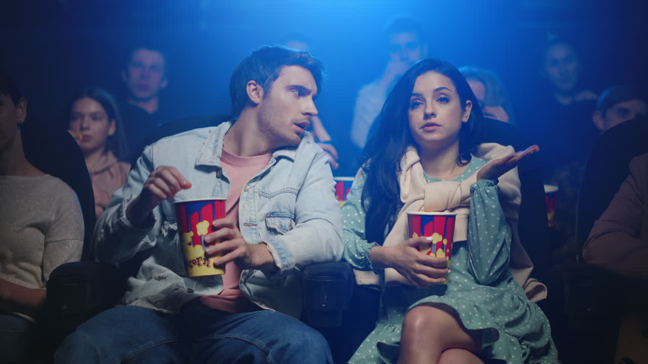 pareja frustrada comiendo en el cine