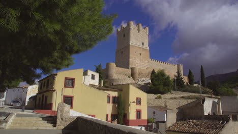 low angle time-lapse view of the atalaya castle making incredible view with clouds is moving under the blue sky, villena, province of alicante, southern spain.