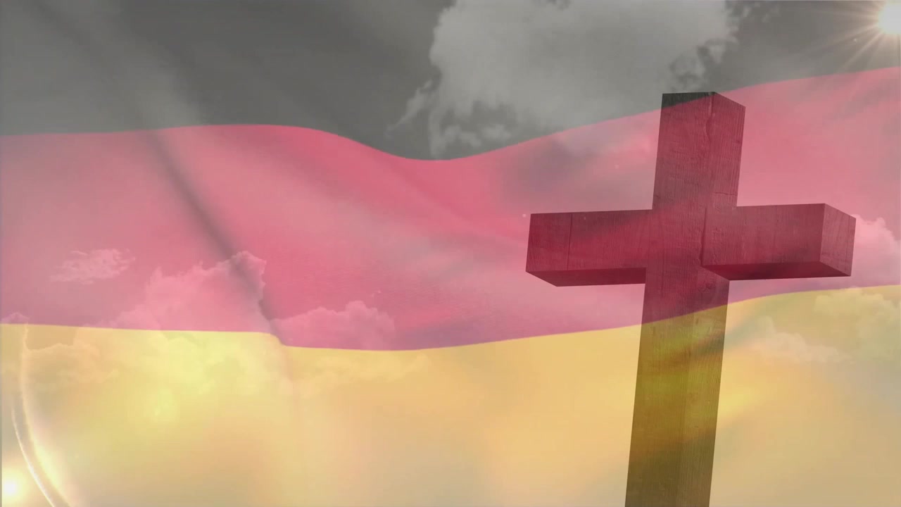 Wind catching German tricolor flag causing rhythmic waving exposing clouds beside wooden cross
