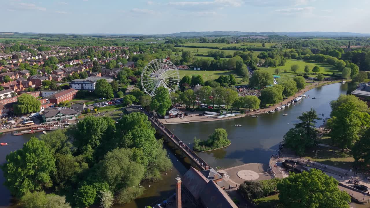 A stunning aerial view of Stratford-upon-Avon showcasing vibrant green nature in bloom, the winding River Avon, and the historic bridge with the town’s charming architecture in the background