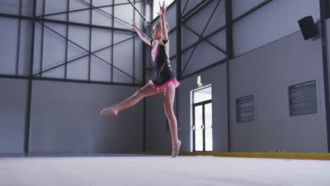 gimnasta adolescente actuando en el salón de deportes