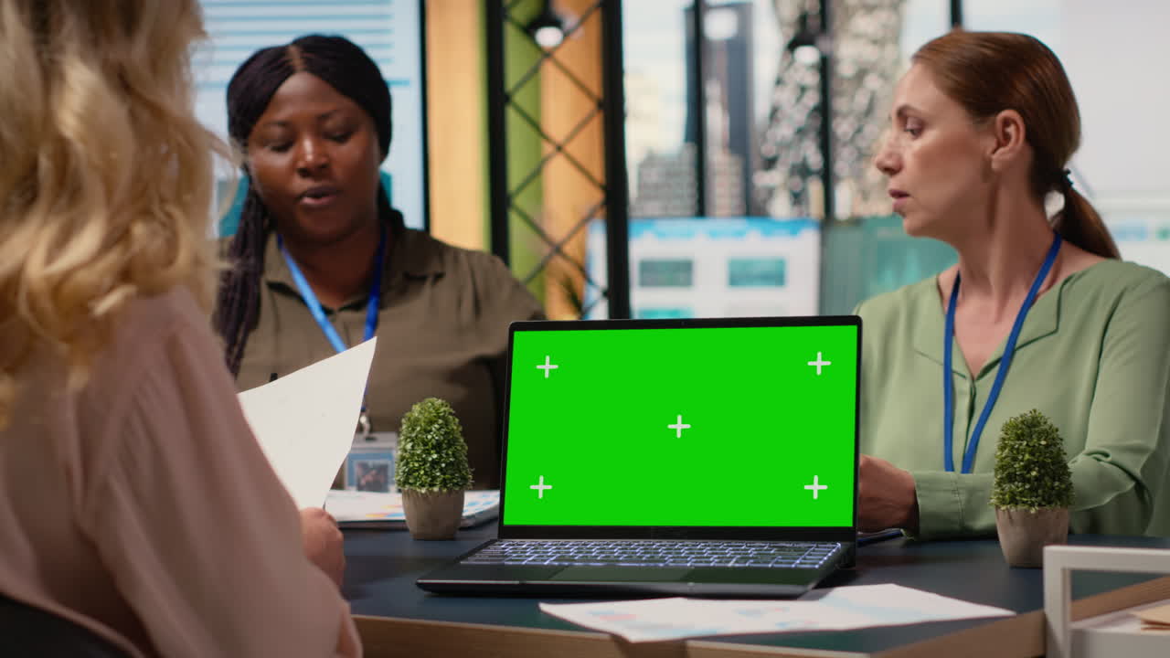 Group of empowered professionals works with green screen on laptop