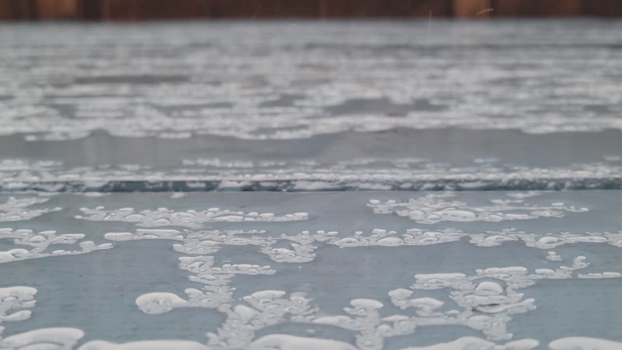 페인트 칠한 나무 파티오 데크에 비가 내린다