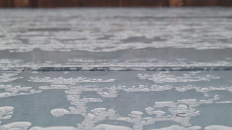 rain falls on a painted wooden patio deck
