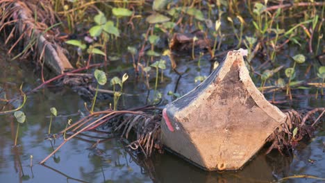 Close-Shot-of-a-Traditional-Wooden-Khmer-Boat-Abandoned-at-the-Side-of-the-River