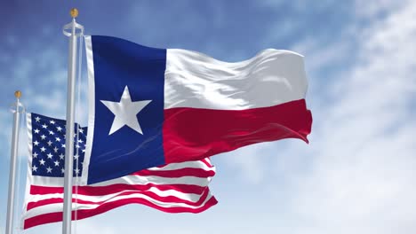 the texas state flag waving along with the national flag of the united states of america