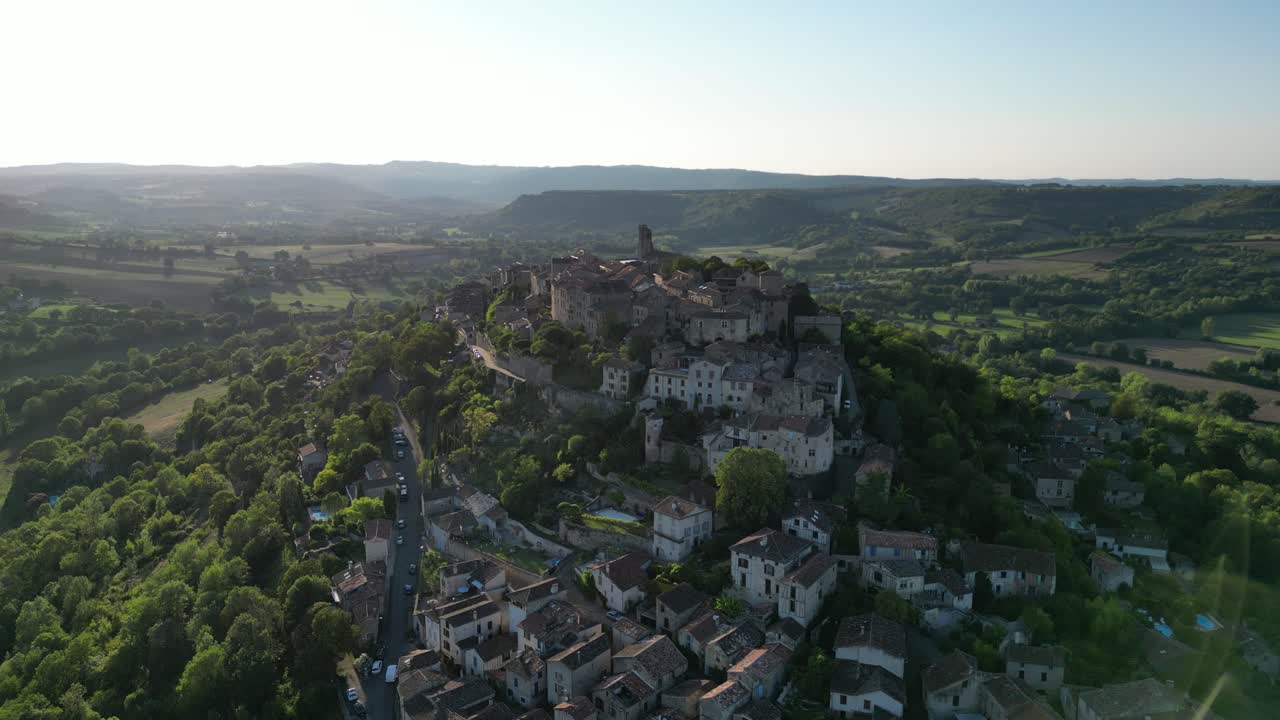 Vista aerea con drone nella campagna francese di una piccola e antica città medievale in mattoni sulla cima di una montagna, ascesa verticale in una giornata di sole a Cordes Sur Ciel