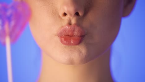 woman kissing a heart shaped lollipop