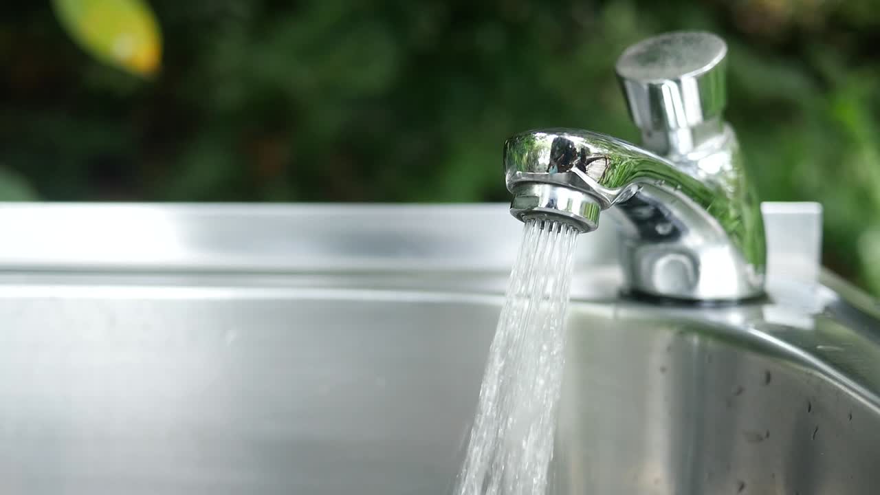 Water flowing from a faucet into a stainless steel sink