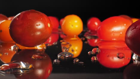 push in macro video of wet cherry tomatoes on a wet reflective surface