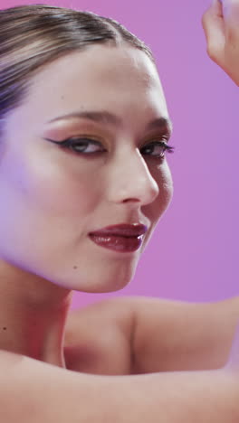 vertical video of caucasian woman with brown hair and make up, copy space, slow motion