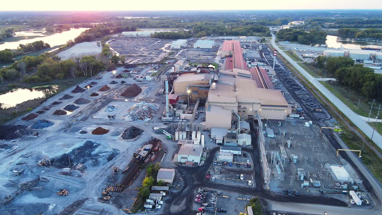 Large Industrial Plant Facility with Raw Material Stockpiles in aerial view